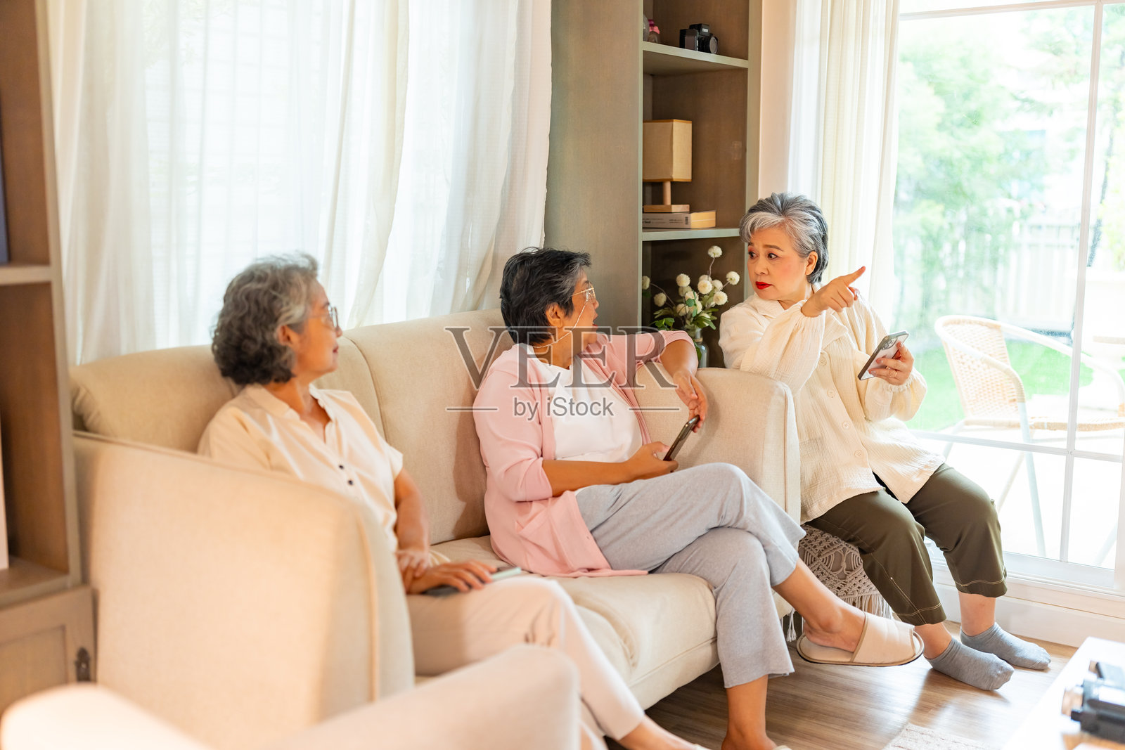 一群亚洲老年女性在家中放松。照片摄影图片