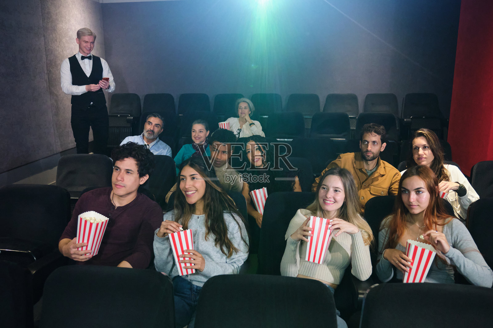 一群人在电影院观看电影并吃爆米花照片摄影图片