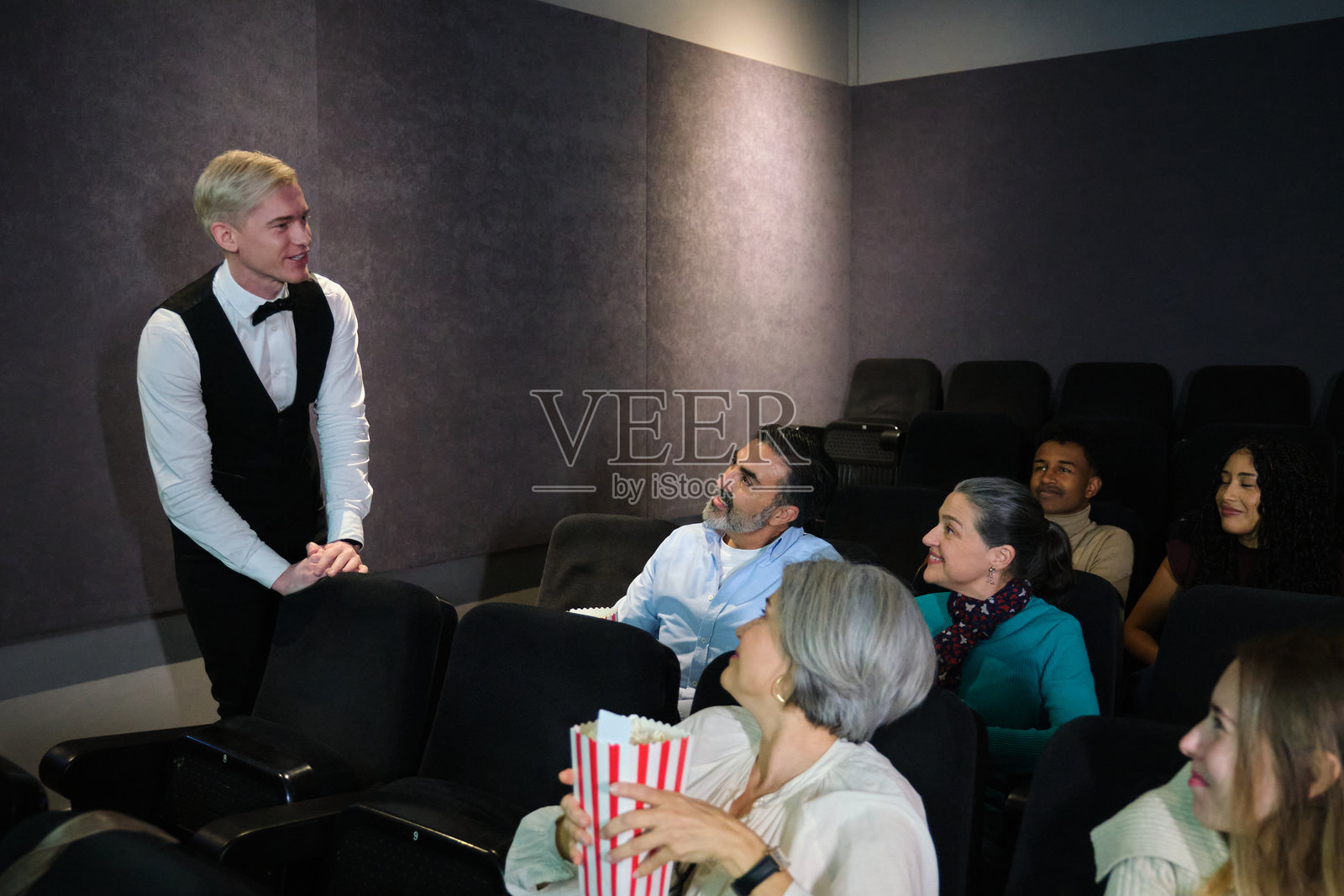 引导员在电影院欢迎观众参加私人放映会照片摄影图片