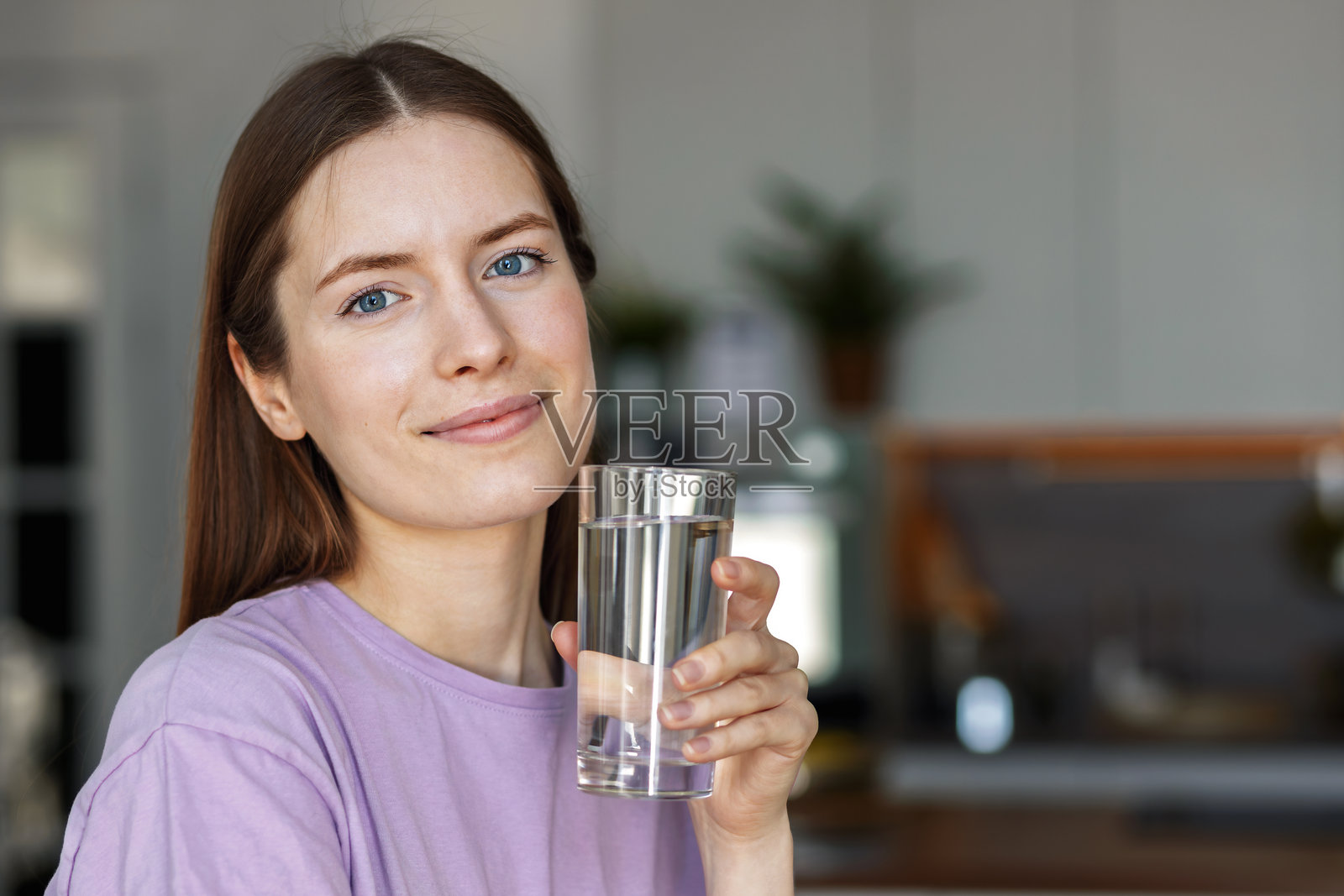 微笑的年轻女性手持一杯水照片摄影图片