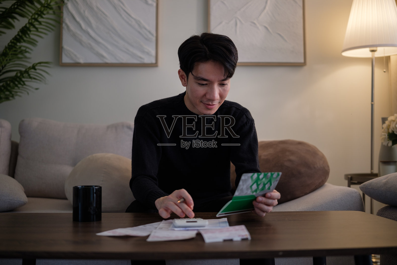 年轻男子在家计算开支和预算。财务管理概念。照片摄影图片