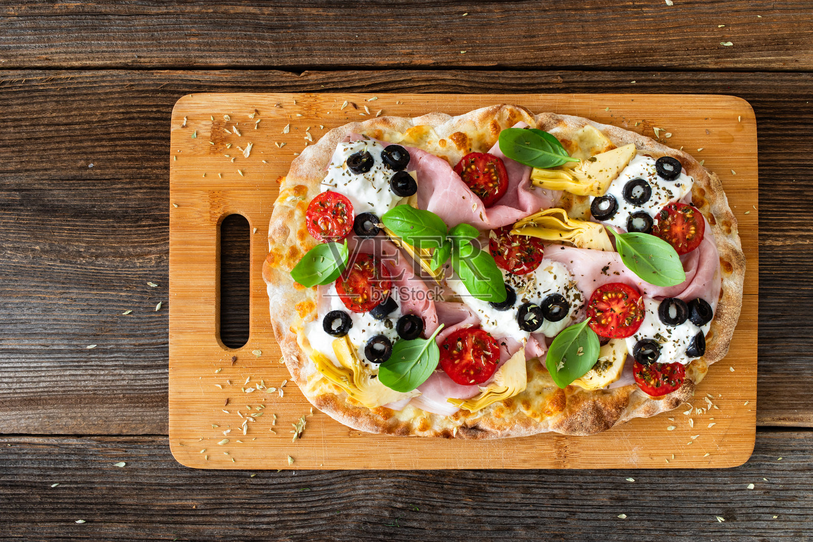 罗马披萨，上面有熟火腿、布拉塔奶酪和蔬菜，放在木桌上照片摄影图片