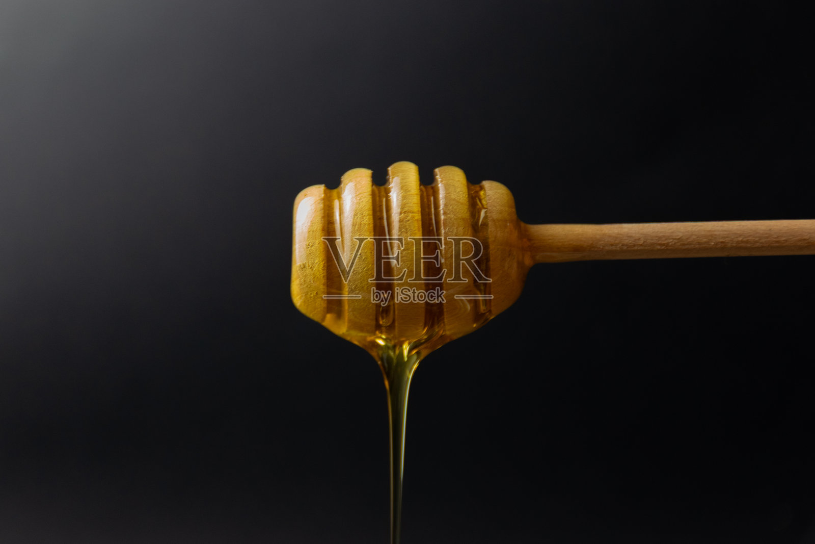 蜜蜂蜜在蜜杖上照片摄影图片