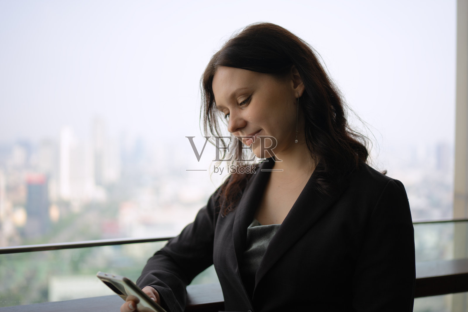 白领在摩天大楼中使用智能手机。照片摄影图片