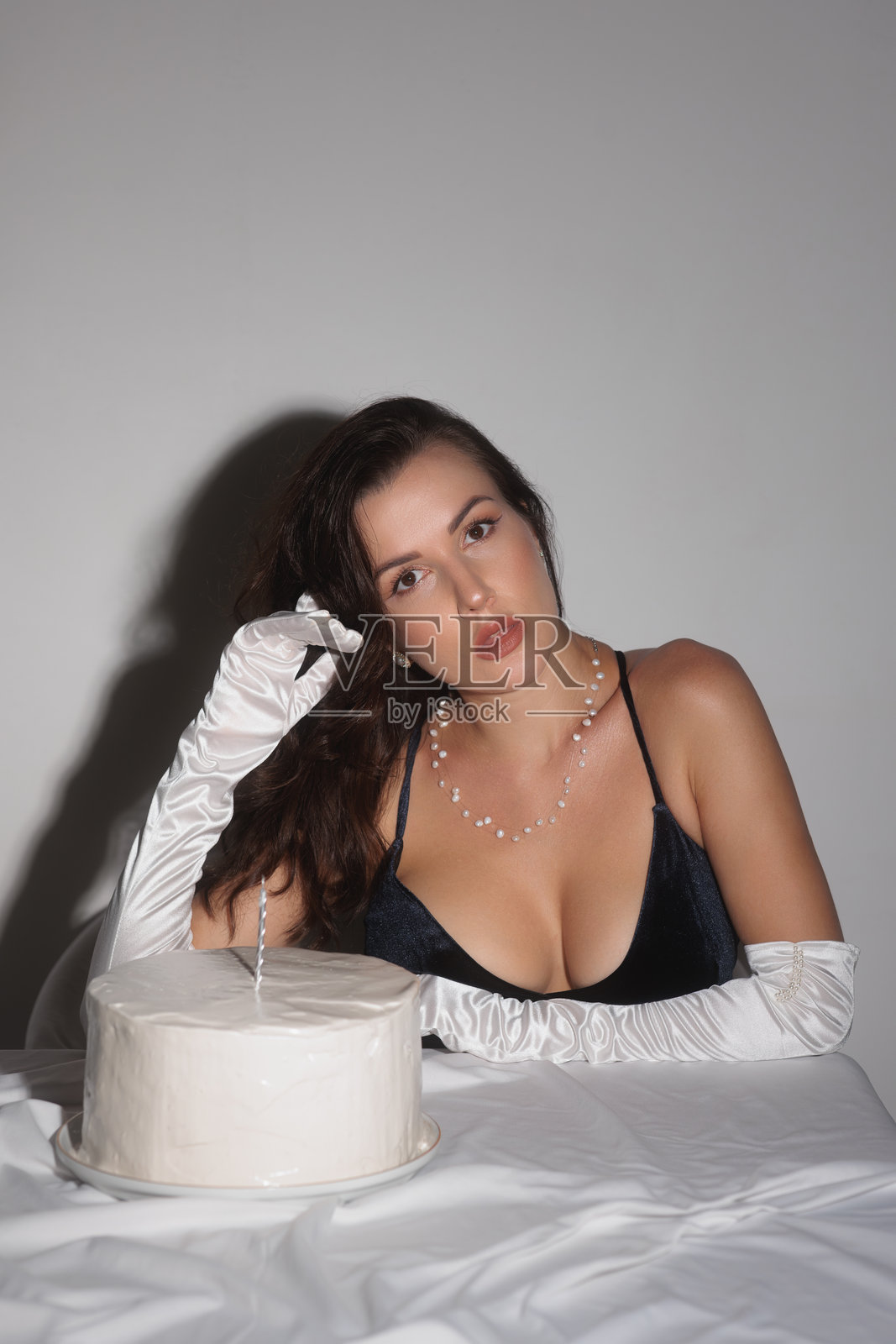 优雅的女性穿着黑色连衣裙庆祝生日，享用蛋糕照片摄影图片