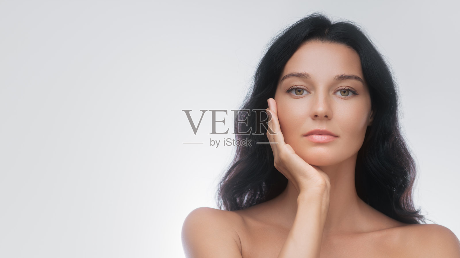 优雅的长发黑发女性以优雅的姿势触摸脸庞照片摄影图片