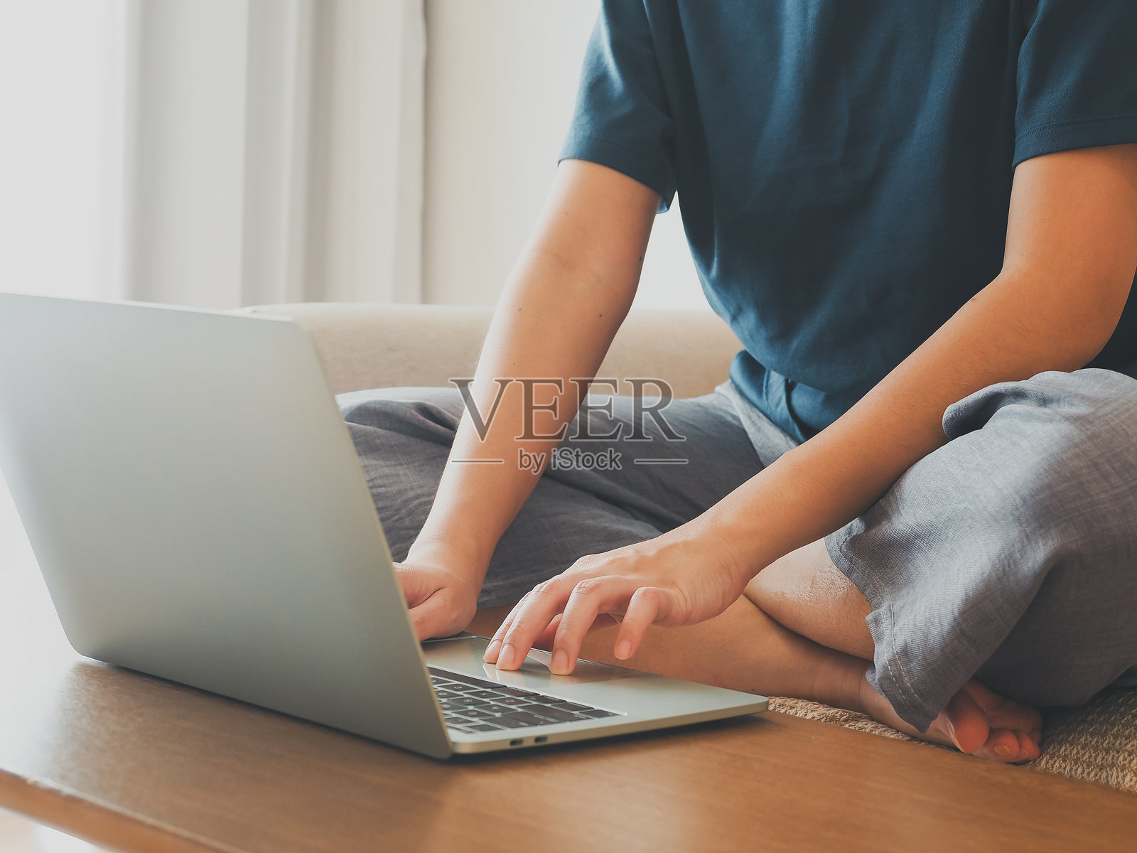 年轻女性在假期期间坐在沙发上用笔记本电脑工作照片摄影图片