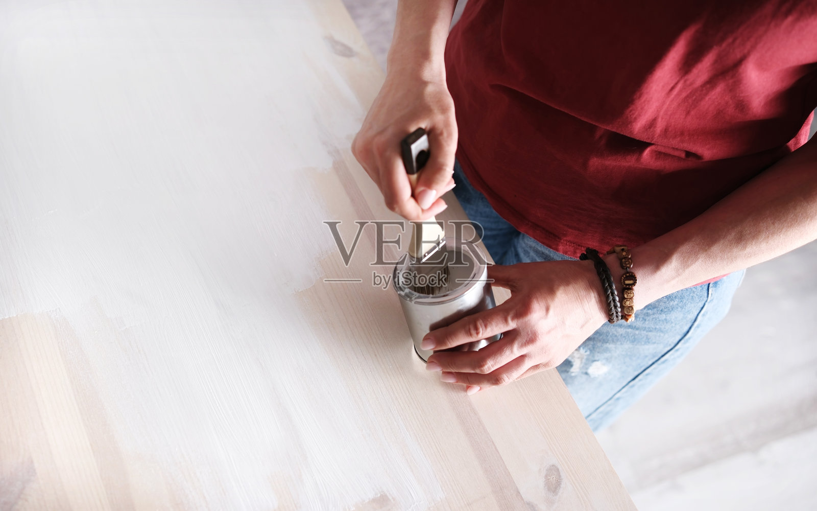 女人用刷子在桌子上涂漆木质表面照片摄影图片