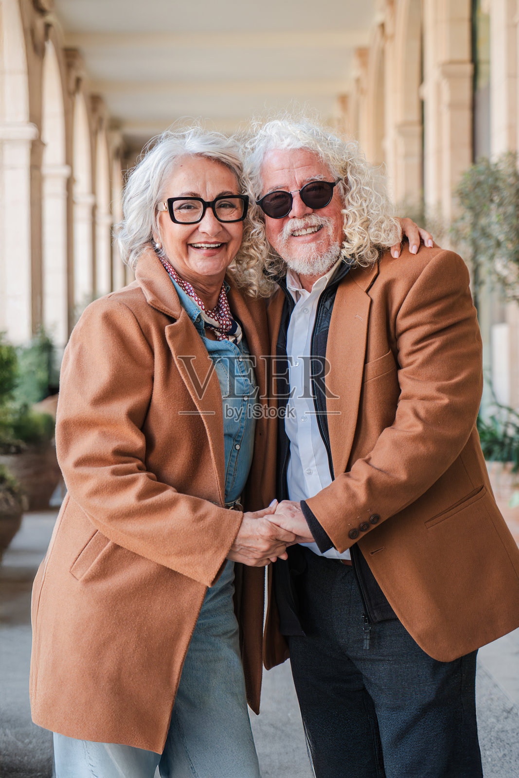 快乐的老年人手牵手，分享温暖的微笑，在风景如画的地方愉快地散步，庆祝他们的终身伴侣关系和浪漫联系。照片摄影图片