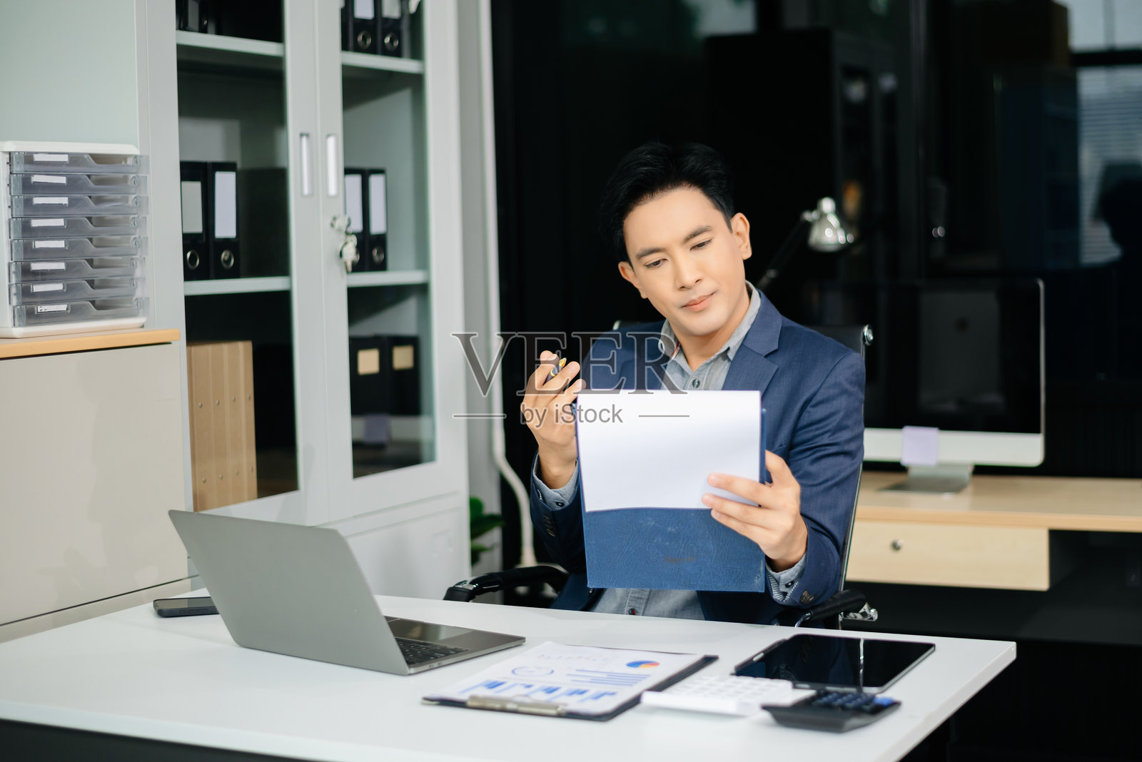 沮丧的年轻商人在工作场所使用笔记本电脑工作照片摄影图片