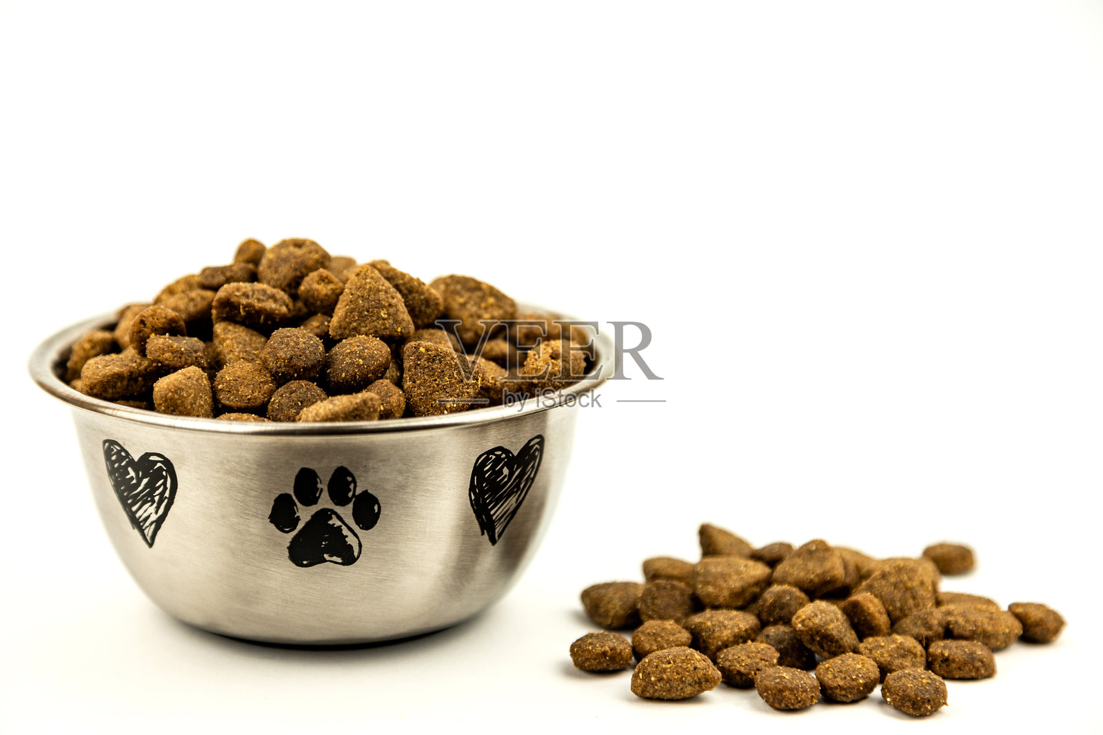 白色背景上的钢盘中盛满干狗粮。照片摄影图片