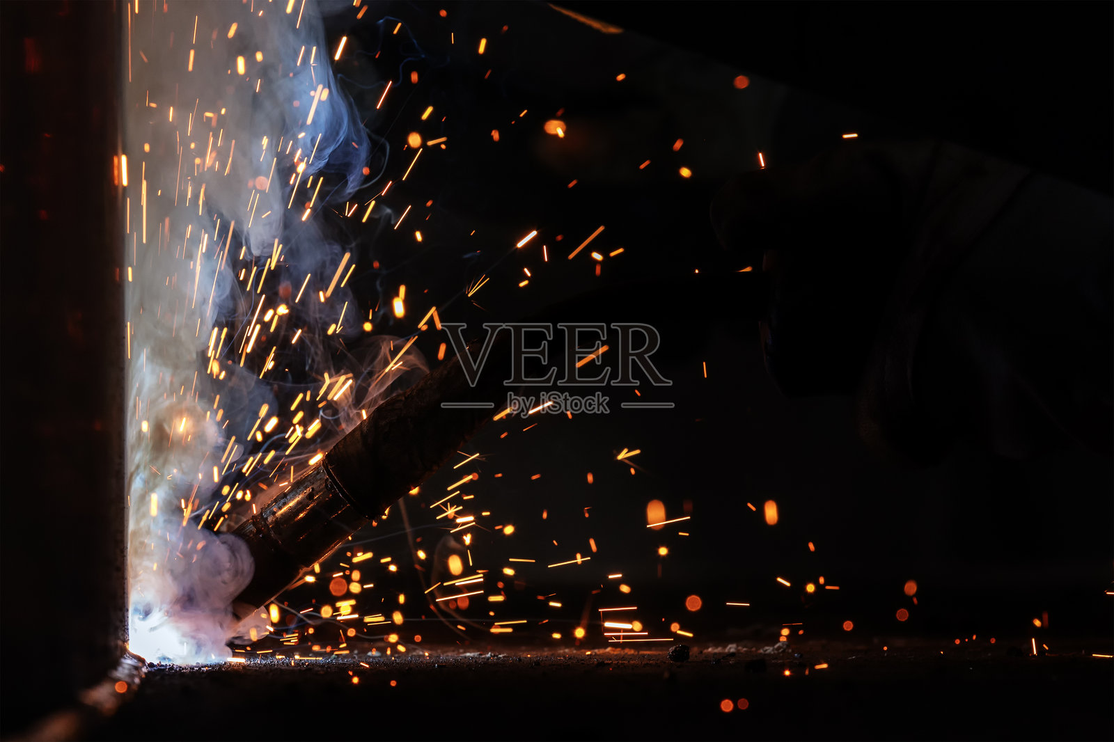 气体金属弧焊（GMAW）过程的背景，伴随火花、光线、散景效果和烟雾。照片摄影图片