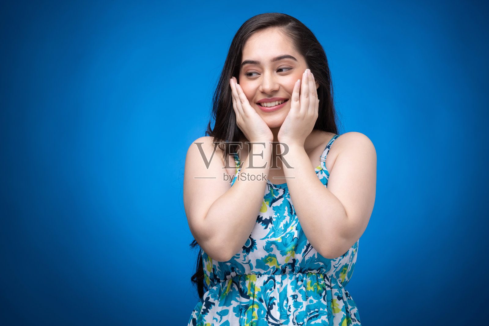 穿着裙子的年轻女性肖像，背景为蓝色照片摄影图片