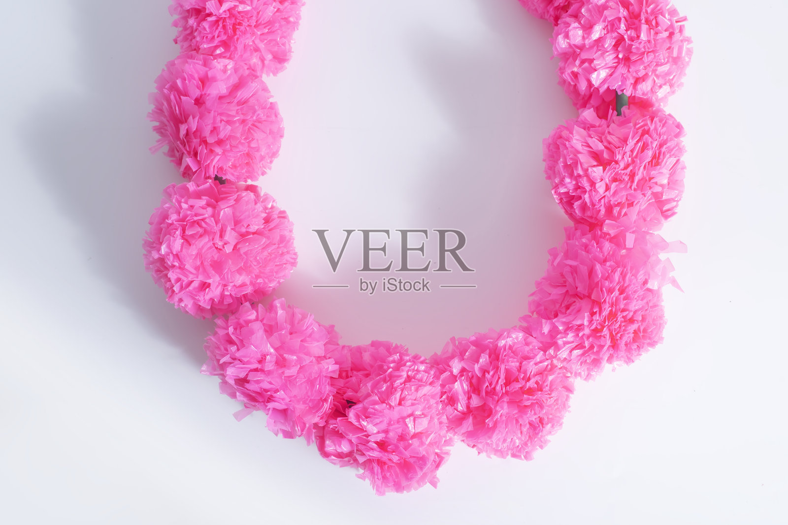 明亮的粉人造花环在白背景上。照片摄影图片