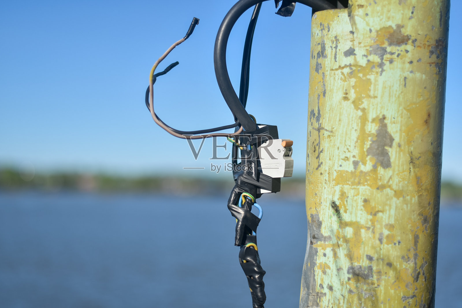 受损的电线。铝制裸线或撕裂的胶带旁边的混凝土电杆。选择性焦点照片摄影图片