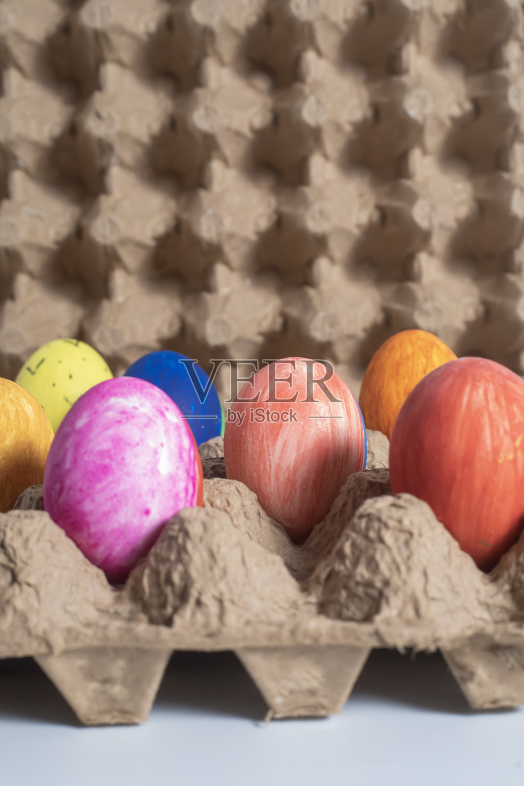 五颜六色的复活节彩蛋放在回收的纸板蛋盒里照片摄影图片