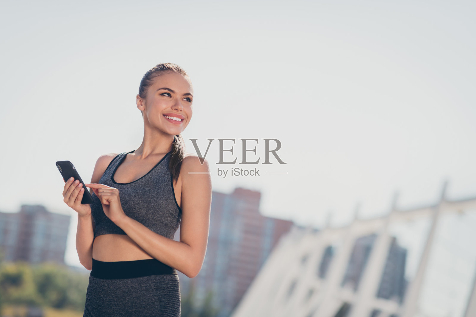 运动积极的女士使用智能设备，打字给朋友，户外做有氧运动，留有空白空间。照片摄影图片