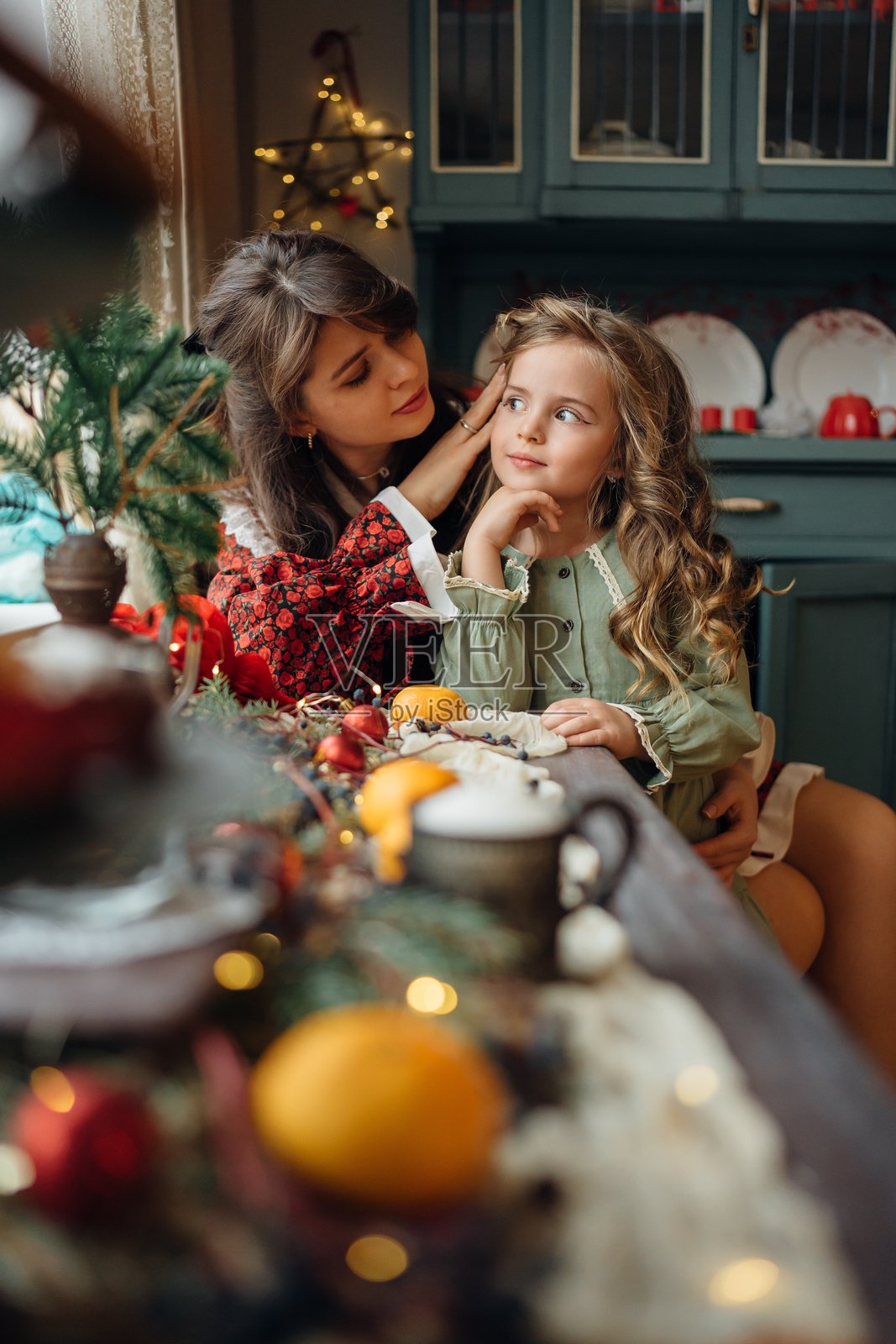 母女在节日的新年餐桌旁。家庭传统。照片摄影图片