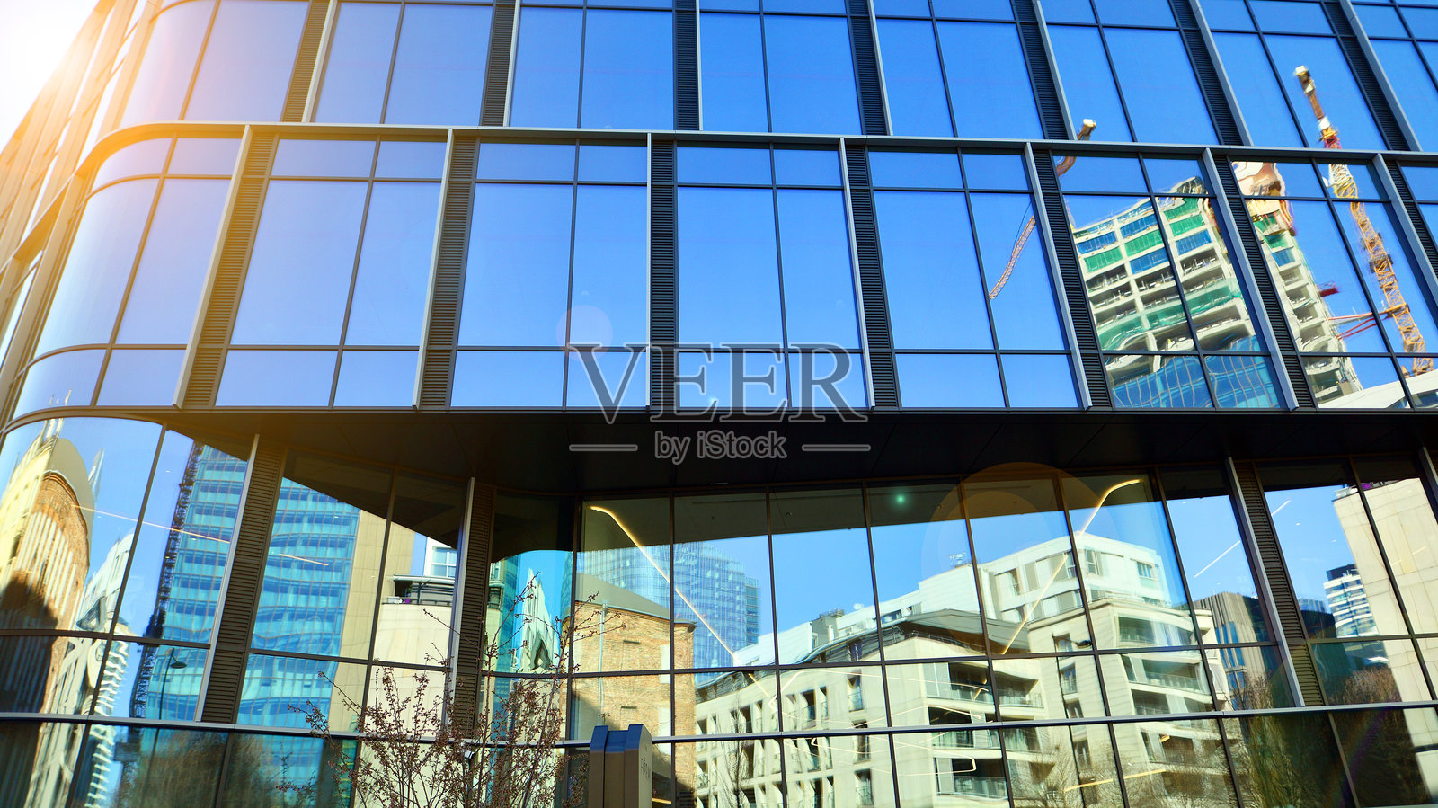 现代办公大楼，玻璃外立面，背景是晴朗的天空。照片摄影图片