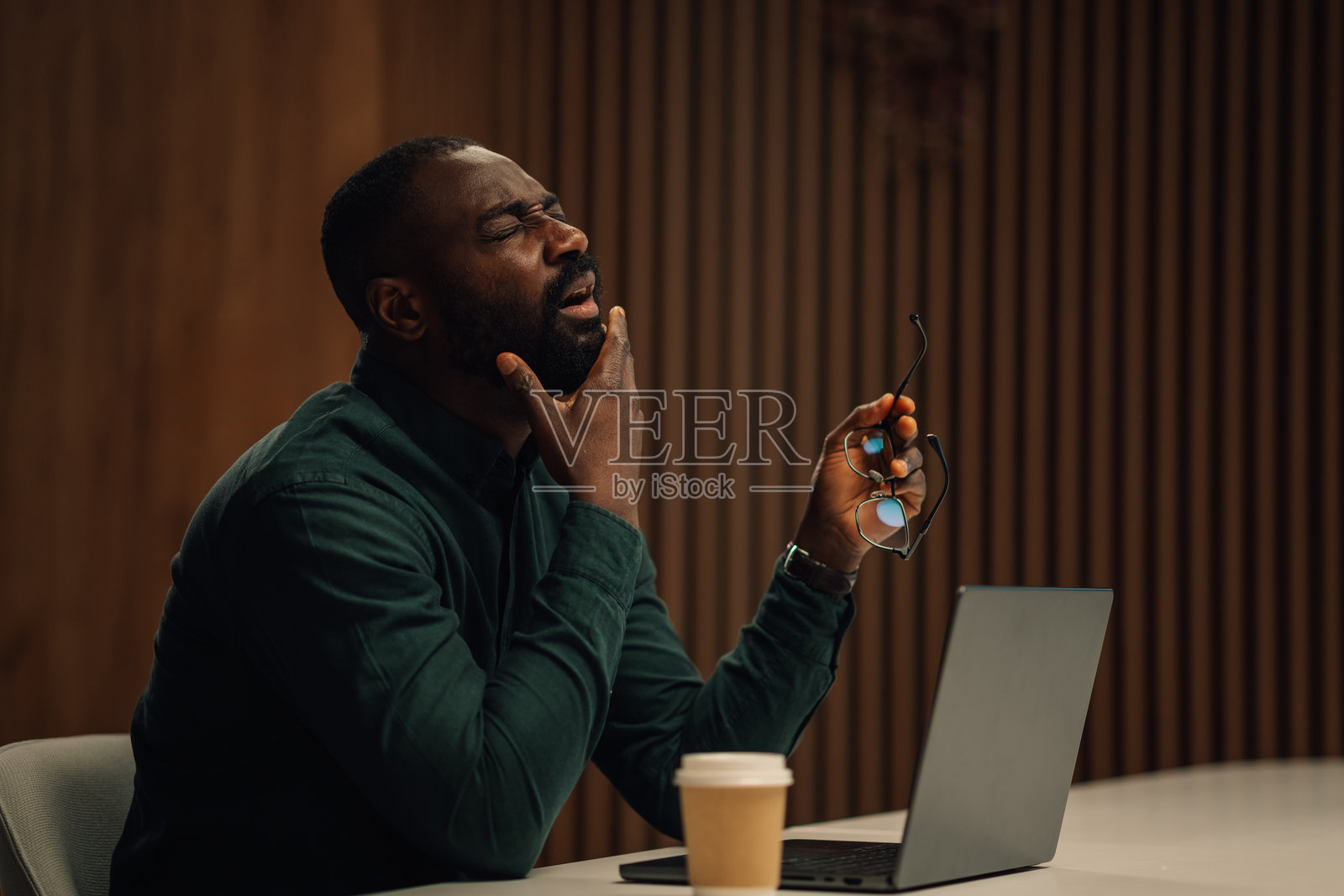 疲惫的商人在办公室加班后按摩脸部照片摄影图片