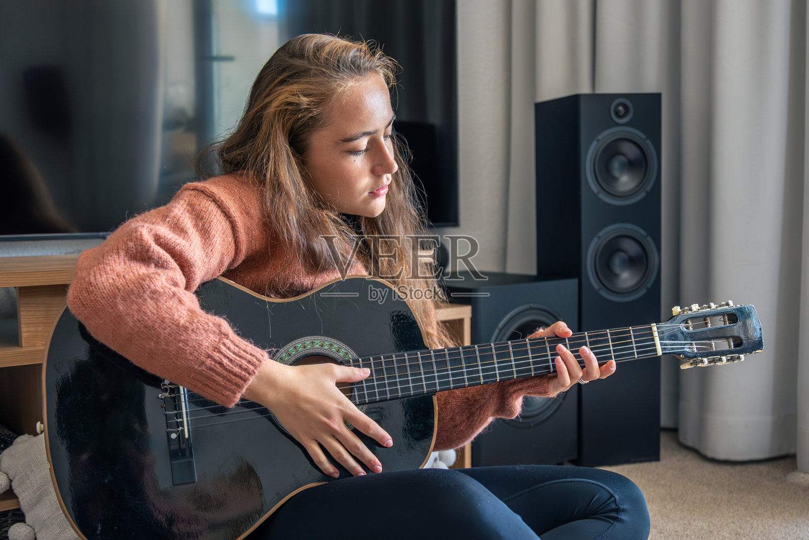 在家弹吉他的少女。吉他。弦乐器。照片摄影图片