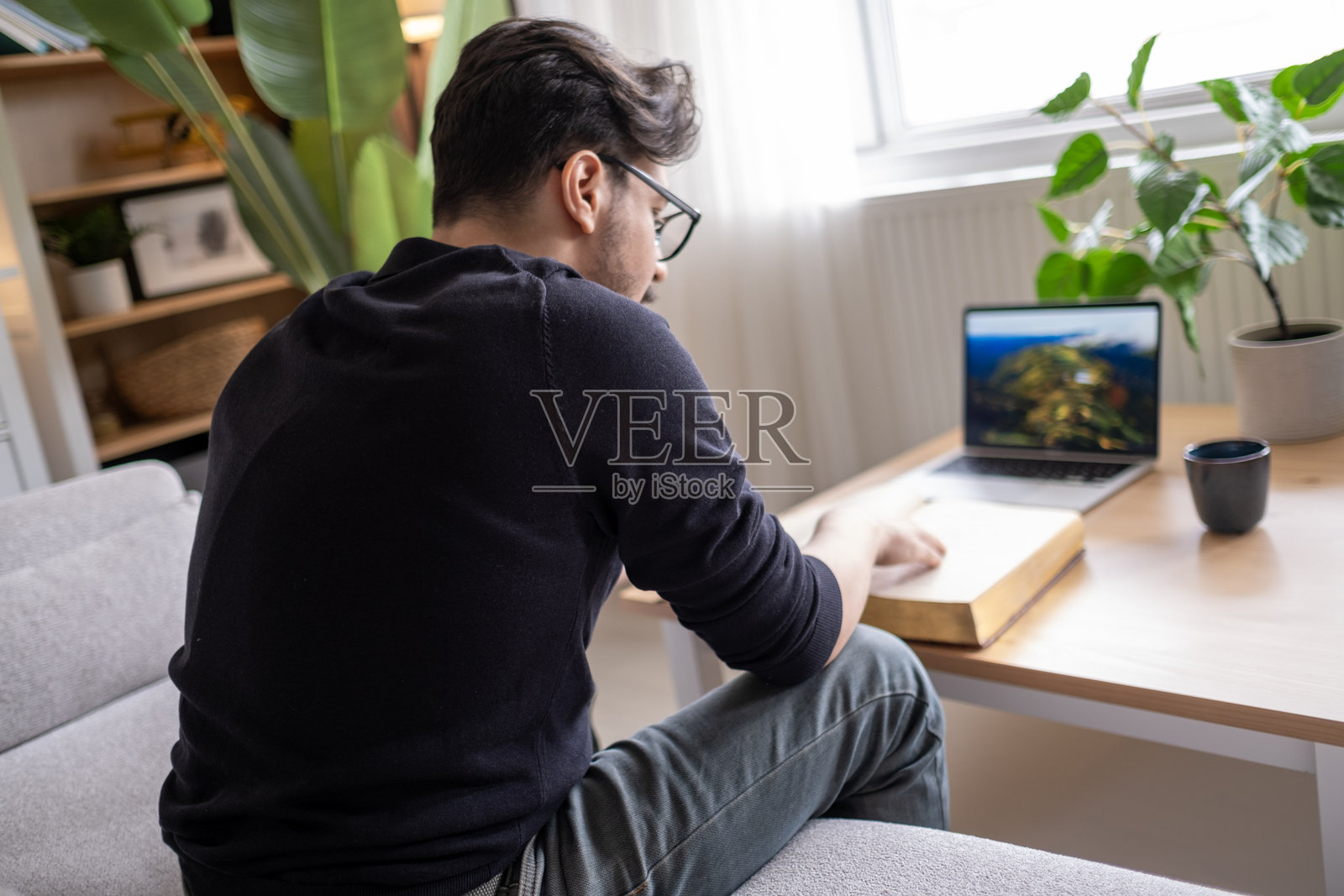 专注的男子在用书本和笔记本电脑学习照片摄影图片