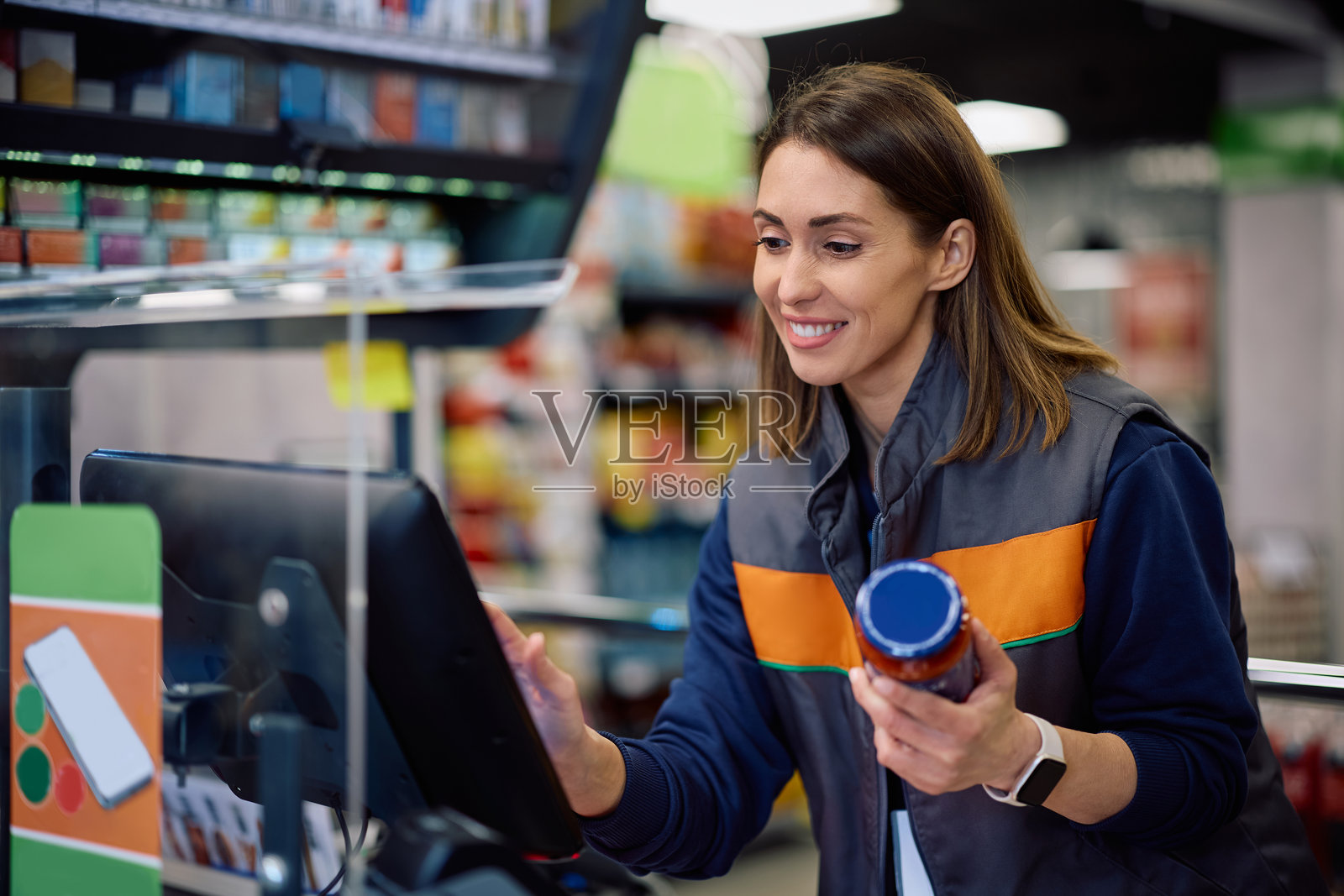 快乐的女收银员在商店收银台工作。照片摄影图片