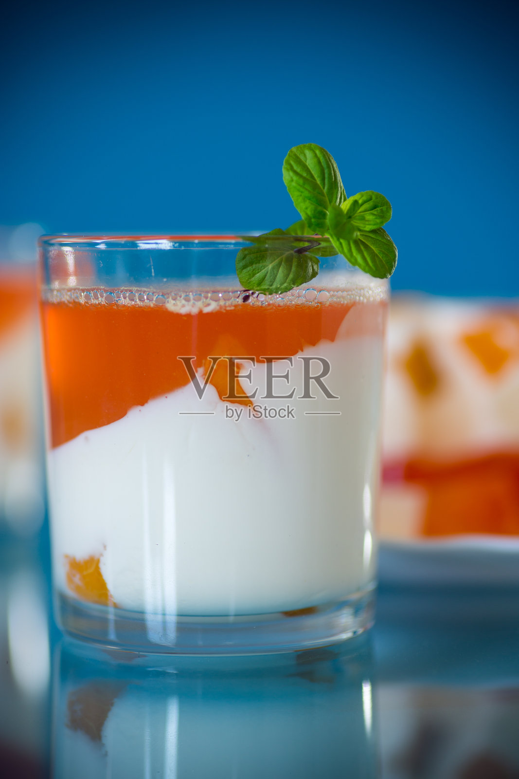 分装在玻璃杯中的果冻甜点，配有酸奶奶油和水果照片摄影图片