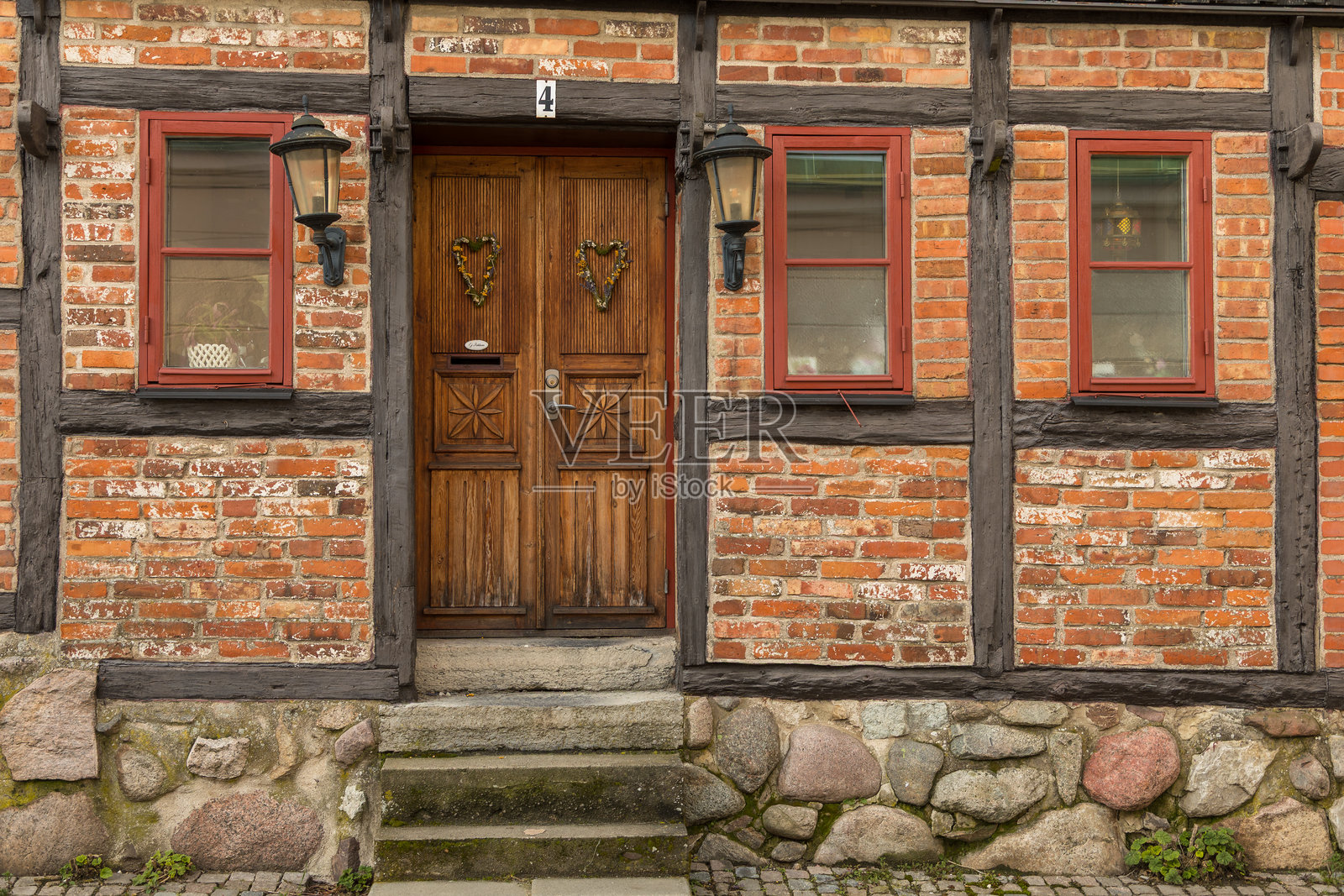 瑞典伊斯塔德的乡村木门和砖砌外墙，配有灯笼。照片摄影图片