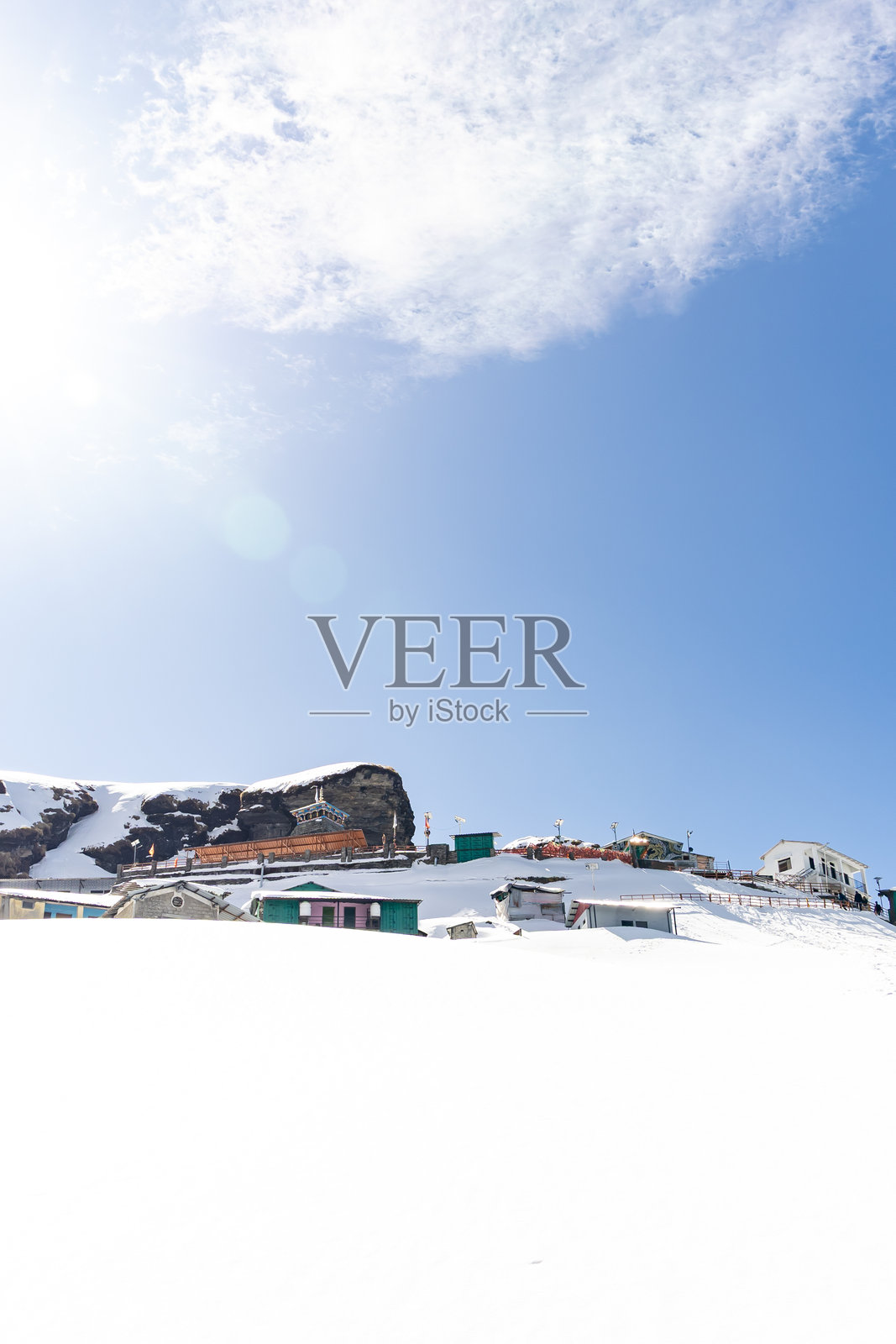 雪覆盖的山脉中的远程避难所，背景是生动的蓝天照片摄影图片