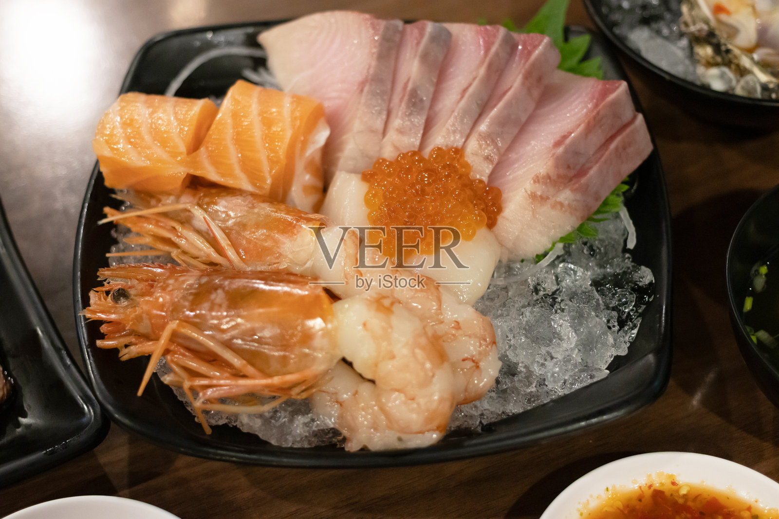 色彩鲜艳的寿司拼盘，搭配新鲜的海鲜美味，放在冰上。照片摄影图片