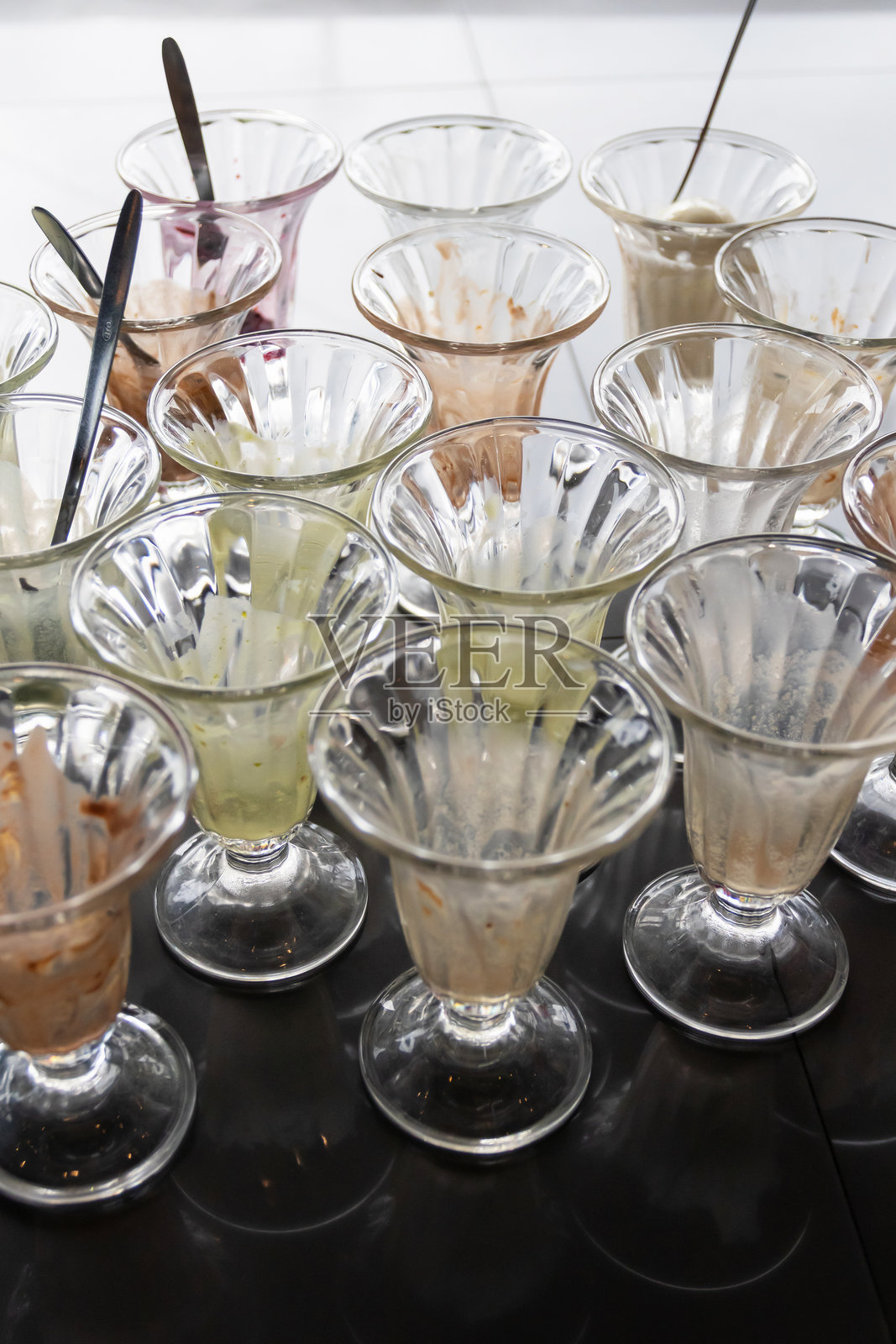 一组精美的甜点杯，盛满了各种口味的美味冰淇淋。照片摄影图片