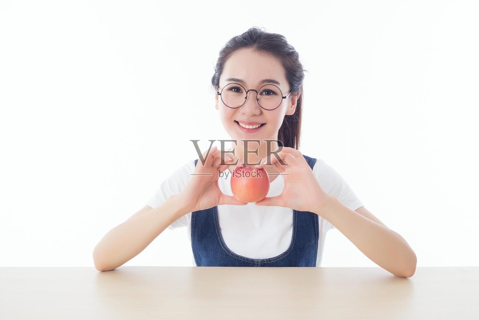 一位女性正在拿着一个苹果照片摄影图片