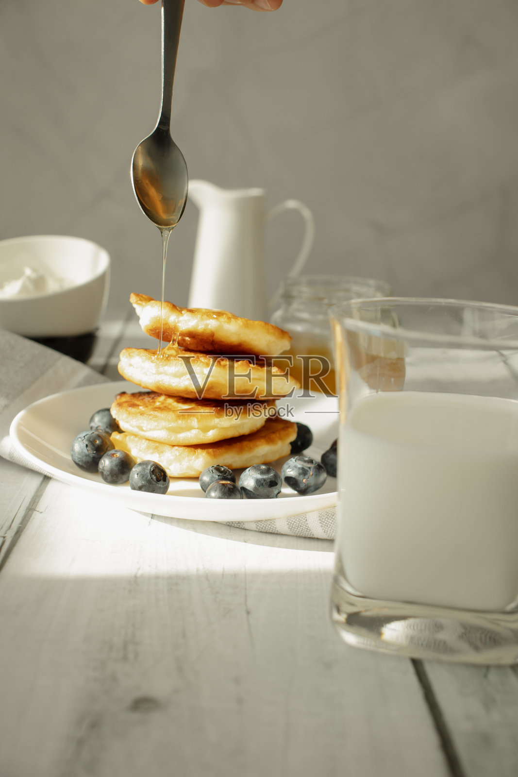 桌子上的煎饼配浆果和蜂蜜。早餐照片摄影图片