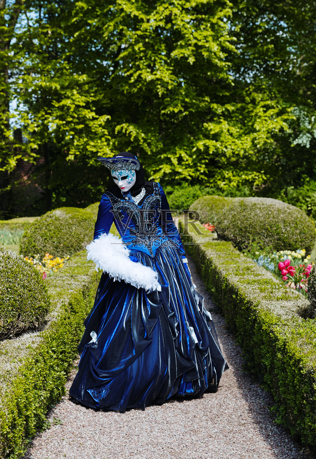 比利时花卉展览上穿着深蓝色威尼斯服装的女孩肖像。照片摄影图片