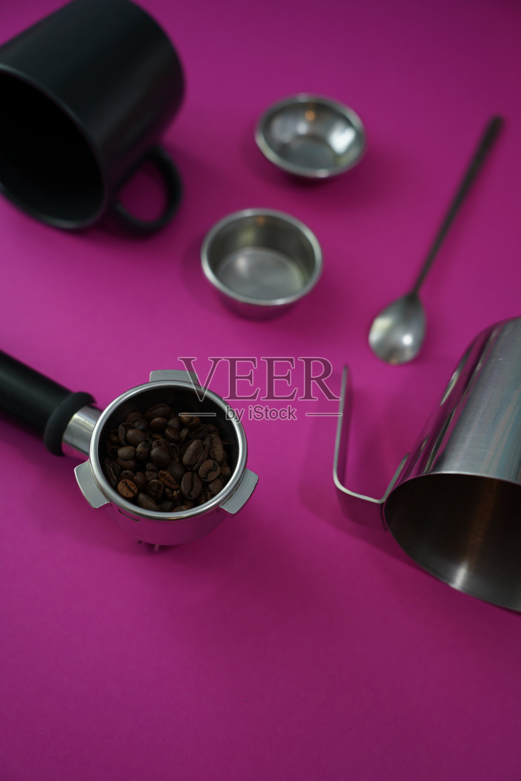 浓缩咖啡机手柄、咖啡豆和咖啡师工具在鲜艳的粉色背景上——完美的浓缩咖啡爱好者和咖啡馆的布置。照片摄影图片