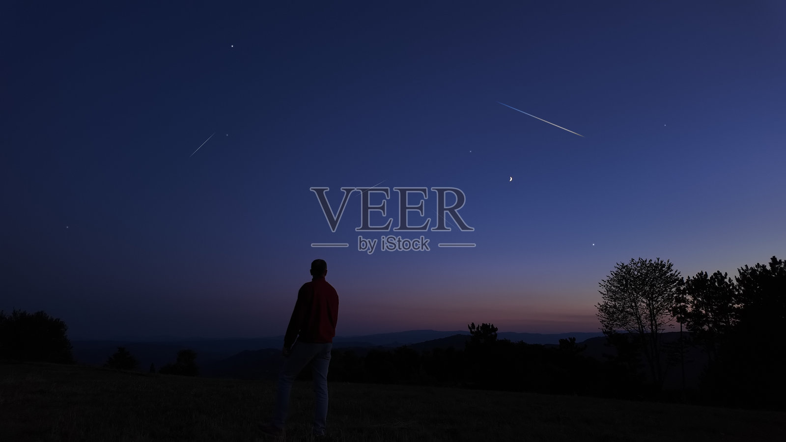 星空和月光下的男人剪影与乡村风景。照片摄影图片