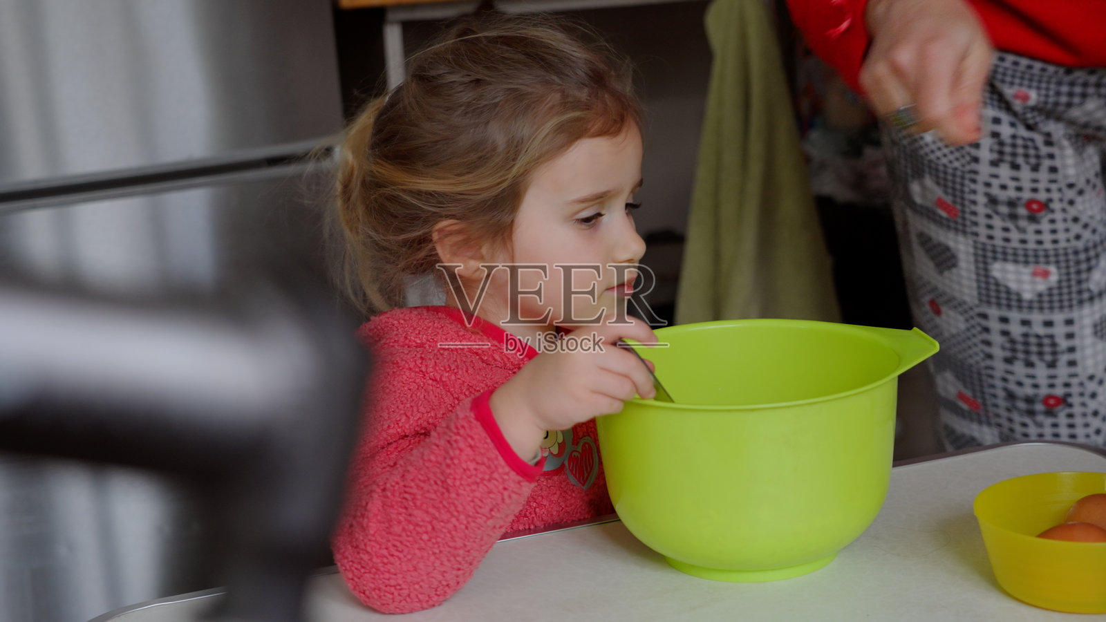 孩子与妈妈一起做蛋糕，促进儿童发展与学习。照片摄影图片