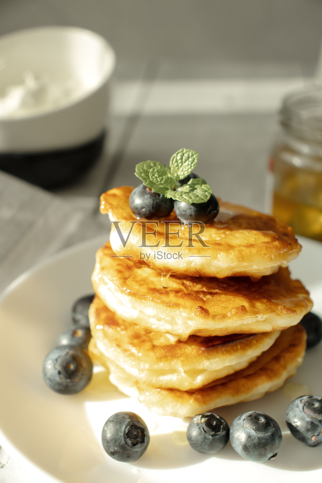 桌子上的煎饼配浆果和蜂蜜。早餐照片摄影图片