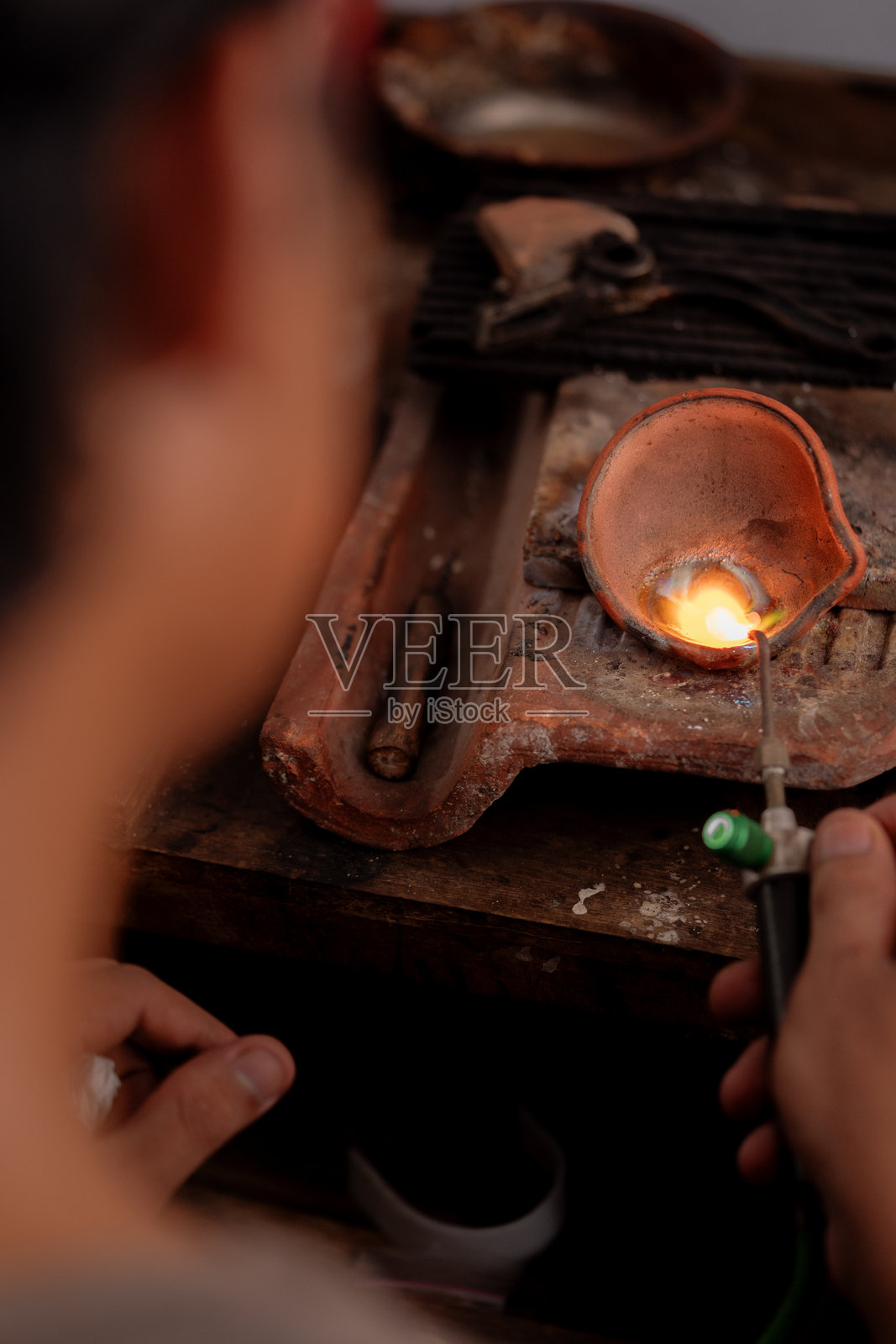 印尼工匠在传统铸造过程中用火炬熔化金属的视角照片摄影图片
