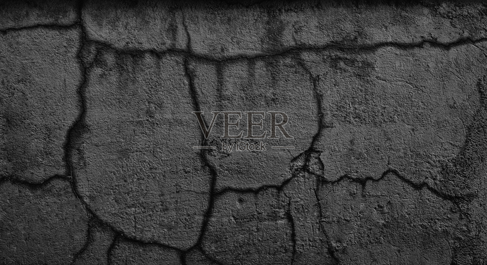 一张黑白照片，展示了一面有裂缝和洞的墙。这面墙看起来很旧，磨损严重。照片摄影图片