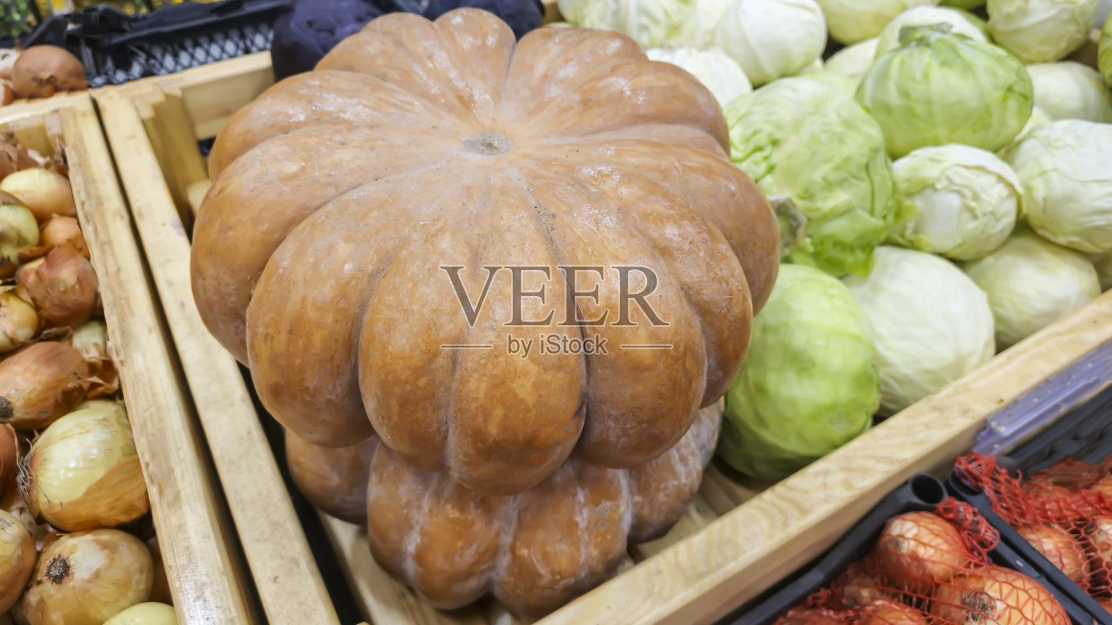 超市柜台上的南瓜、卷心菜和其他蔬菜。照片摄影图片