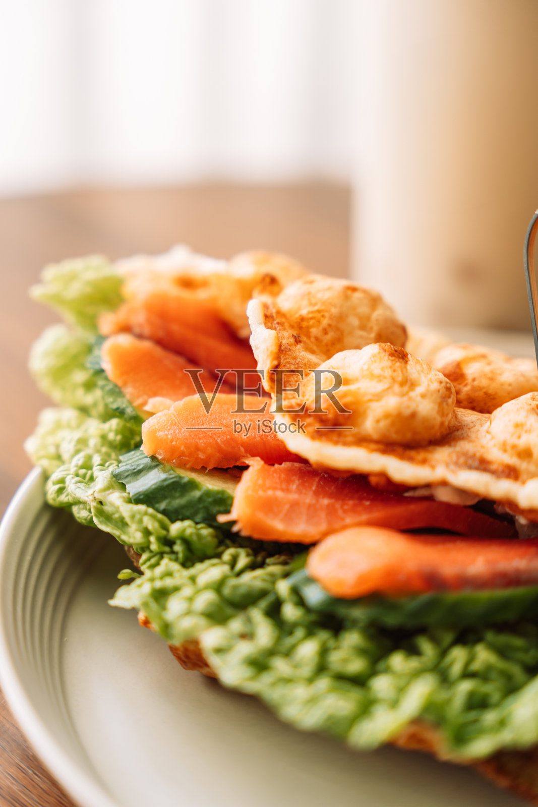 三明治泡芙华夫饼配三文鱼、奶酪和香草，旁边有饮料，放在木桌上照片摄影图片