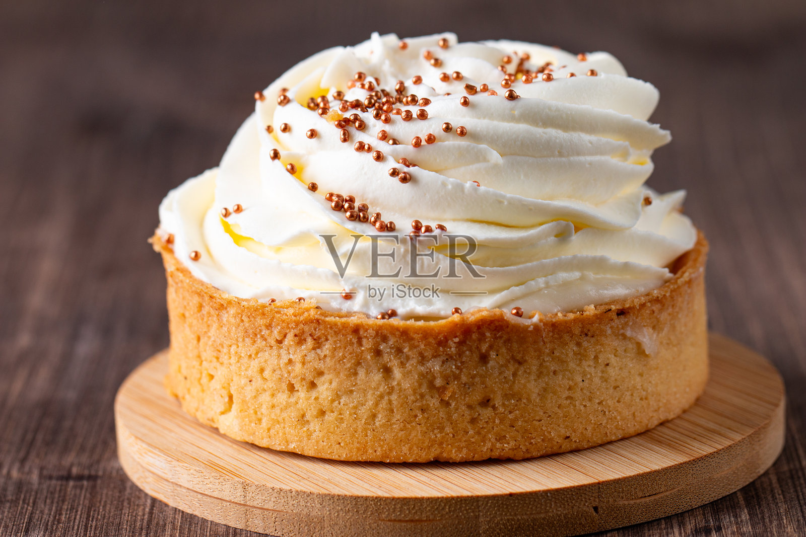 柠檬塔饼上放有鲜奶油、糖屑和巧克力豆，背景为白色。照片摄影图片