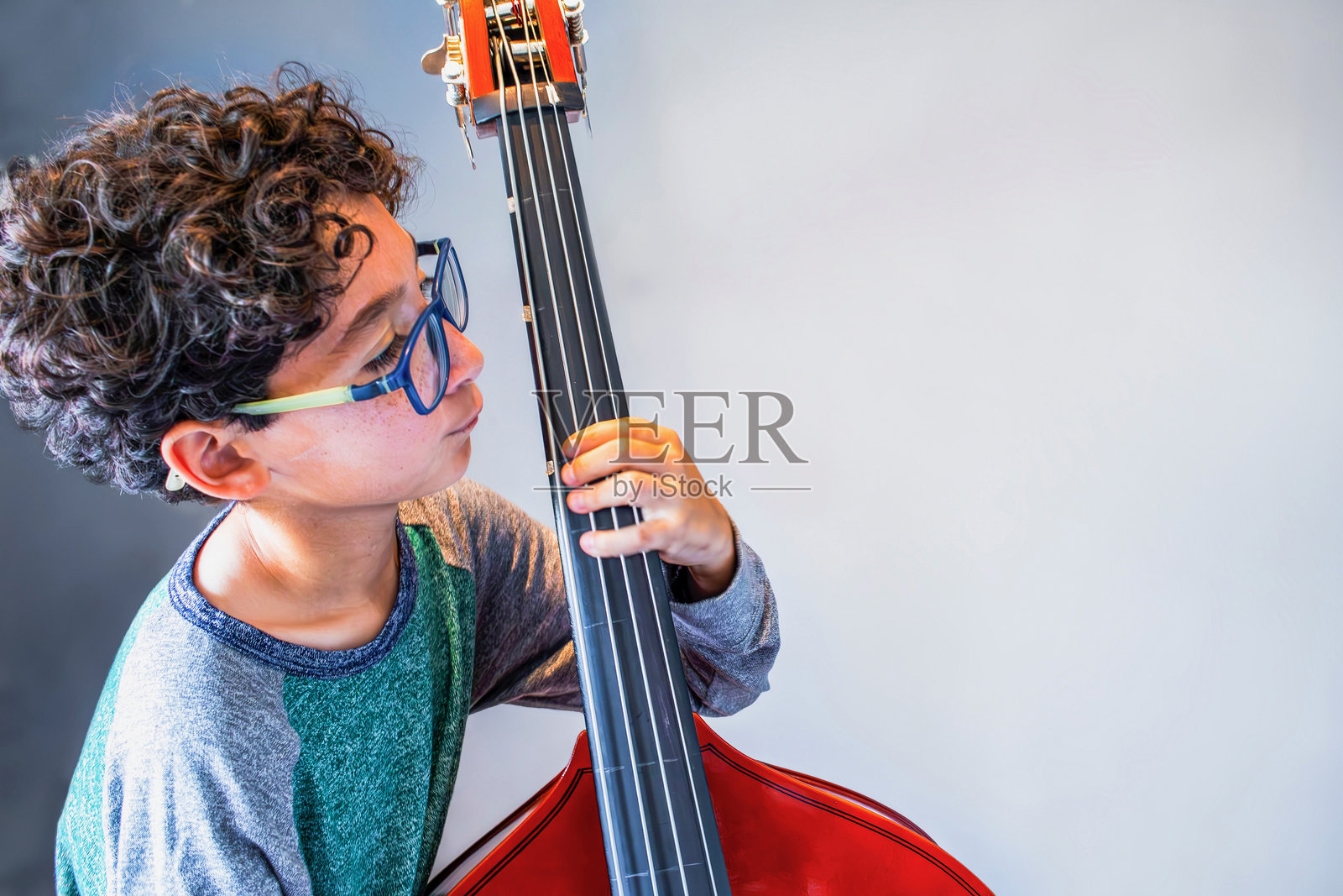 充满热情和灵感专注的年轻低音大提琴演奏家照片摄影图片