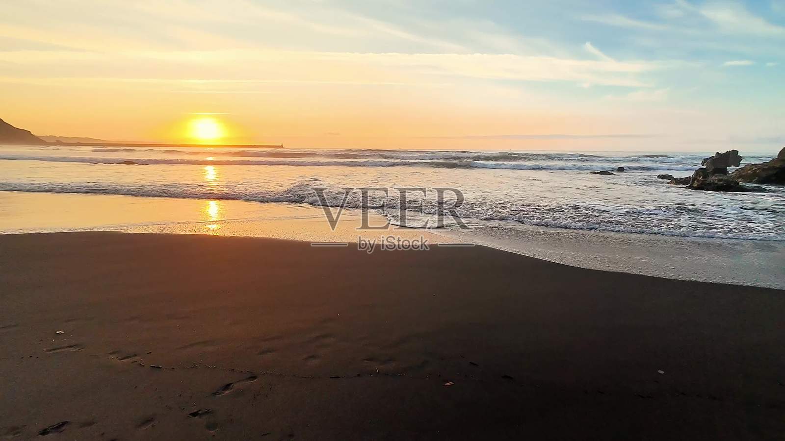 宁静的海滩日落，波浪平静，色彩鲜艳，风景优美照片摄影图片