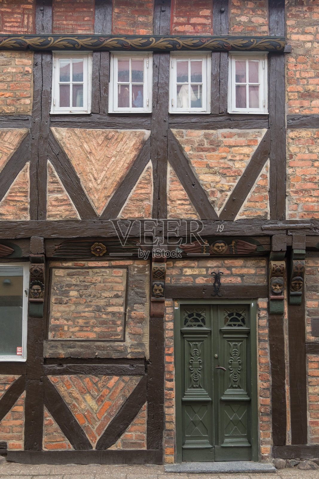 瑞典伊斯塔德的传统半木结构外立面，配有绿色门。照片摄影图片