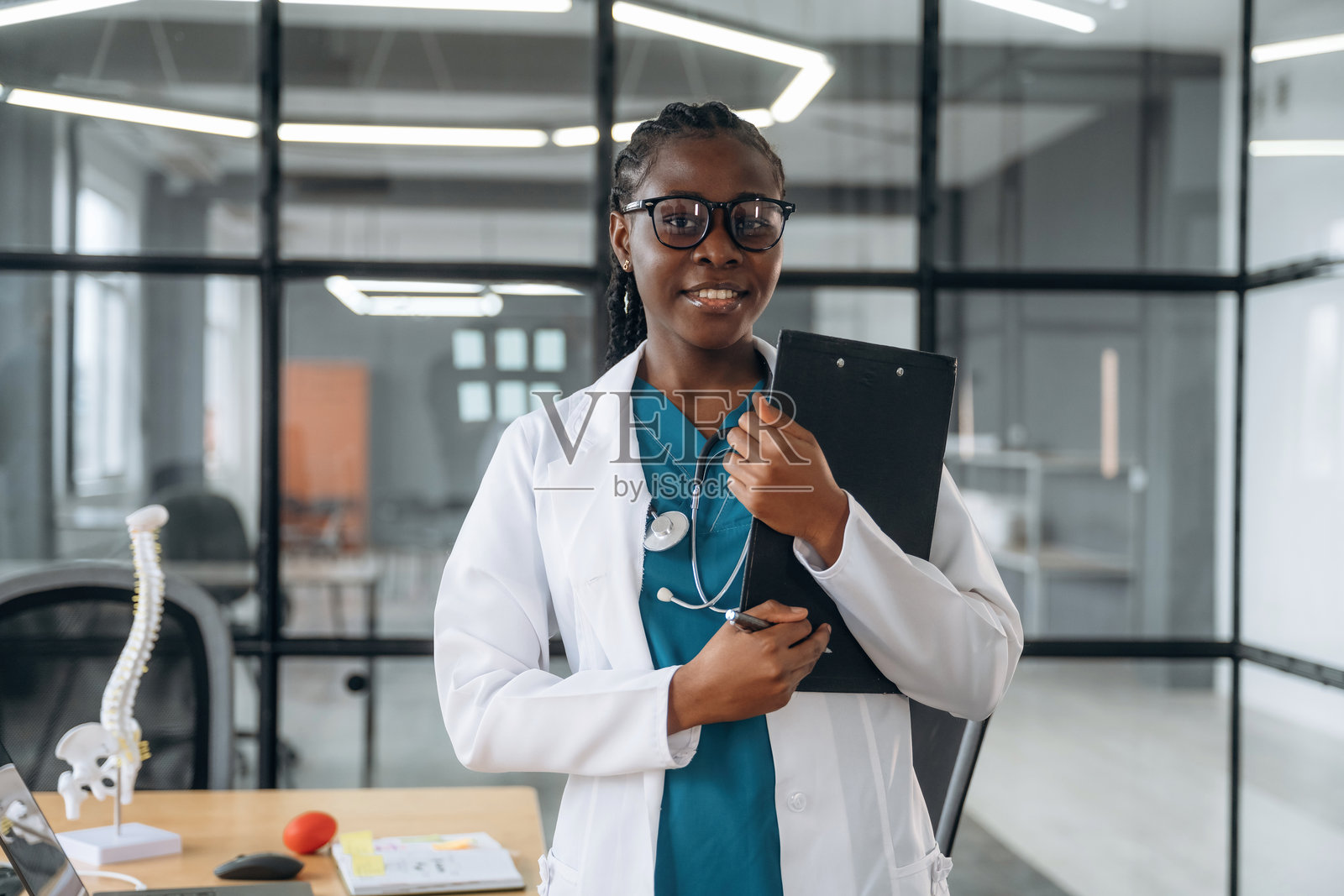 穿着白大褂的女医生在诊所办公室里。照片摄影图片