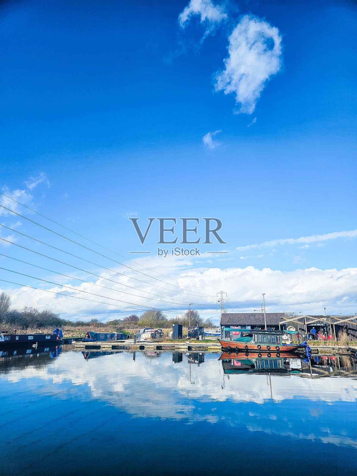 苏格兰河岸色彩斑斓的船只和房屋，蓝天与倒影相映成趣照片摄影图片