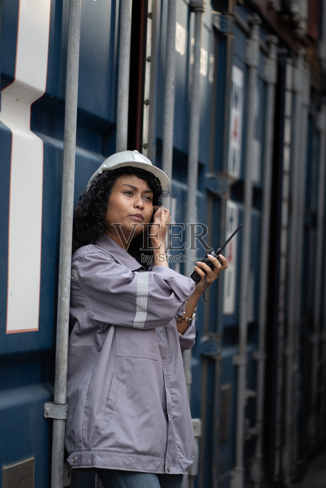 亚洲女工在集装箱场地使用对讲机检查集装箱照片摄影图片